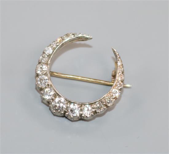 An early-mid 20th century yellow and white metal, diamond set crescent brooch, 21mm.